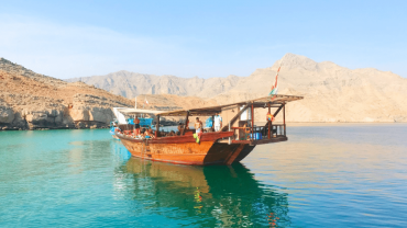 رحلة بحرية على متن قارب عماني تقليدي عند غروب الشمس في مسقط